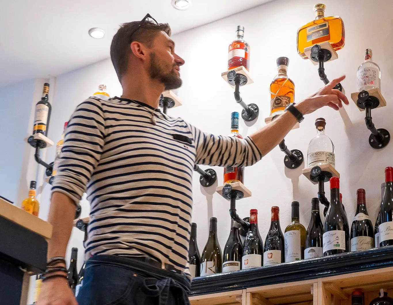 Jean-Marc, le passionné sommelier du P'tit Cru, présentant sa sélection de vins, illustrant son expertise et son engagement envers la qualité.